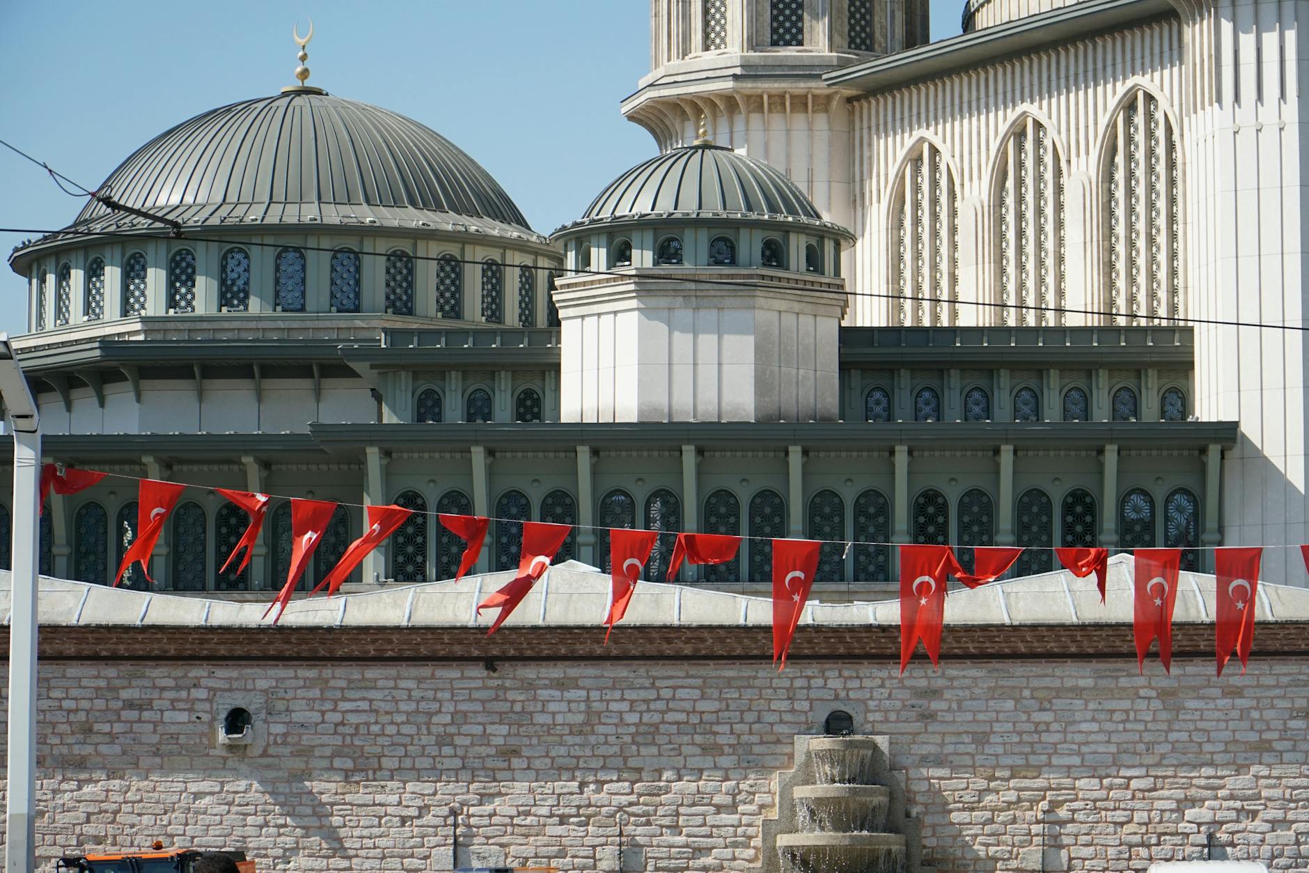 Taksim Mosque surrounded by Turkish flags, a blend of tradition and modernity in Istanbul.
