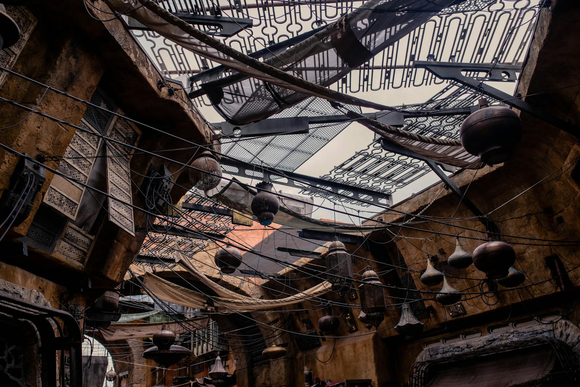 Intricate ceiling design with hanging pots and wires in an Orlando marketplace.
