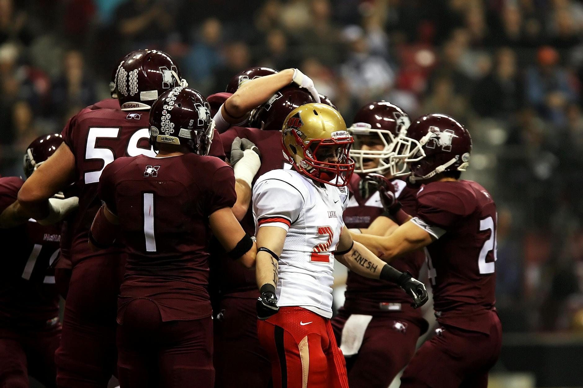 Football players in action celebrating a play on the field during a college game.