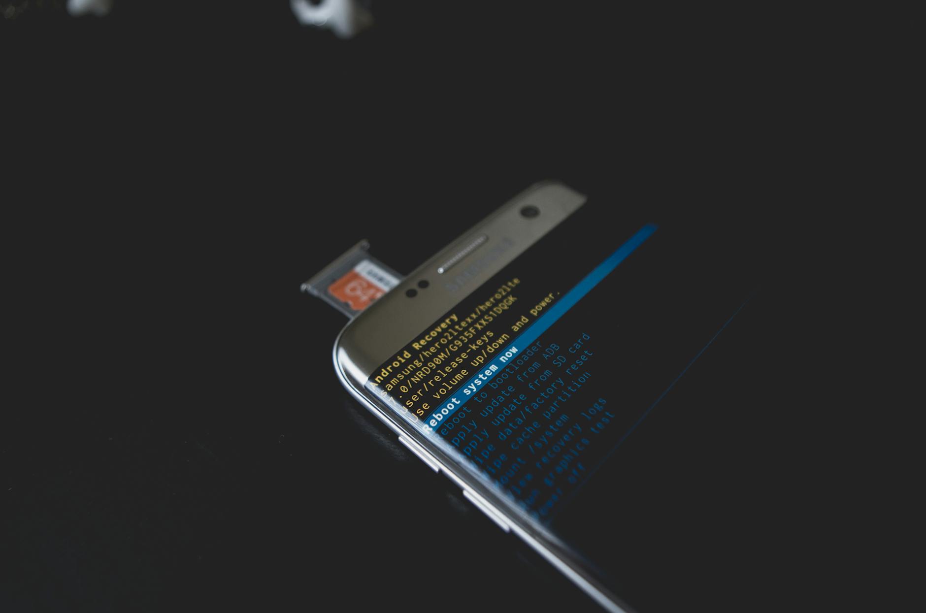 Close-up of a smartphone displaying Android recovery mode with an SD card inserted.