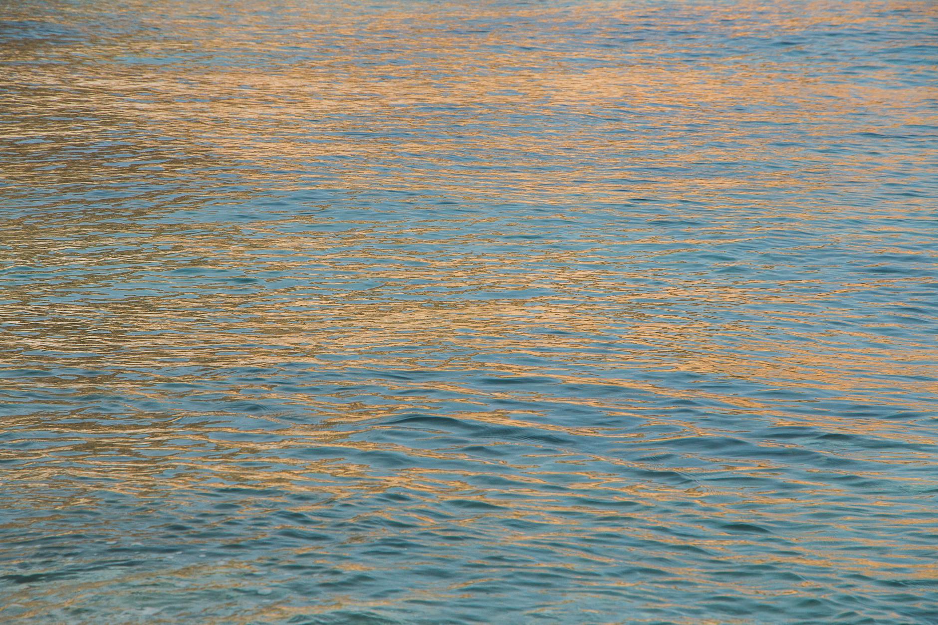 Golden reflections ripple across the blue sea in Almería, creating a serene and captivating view.