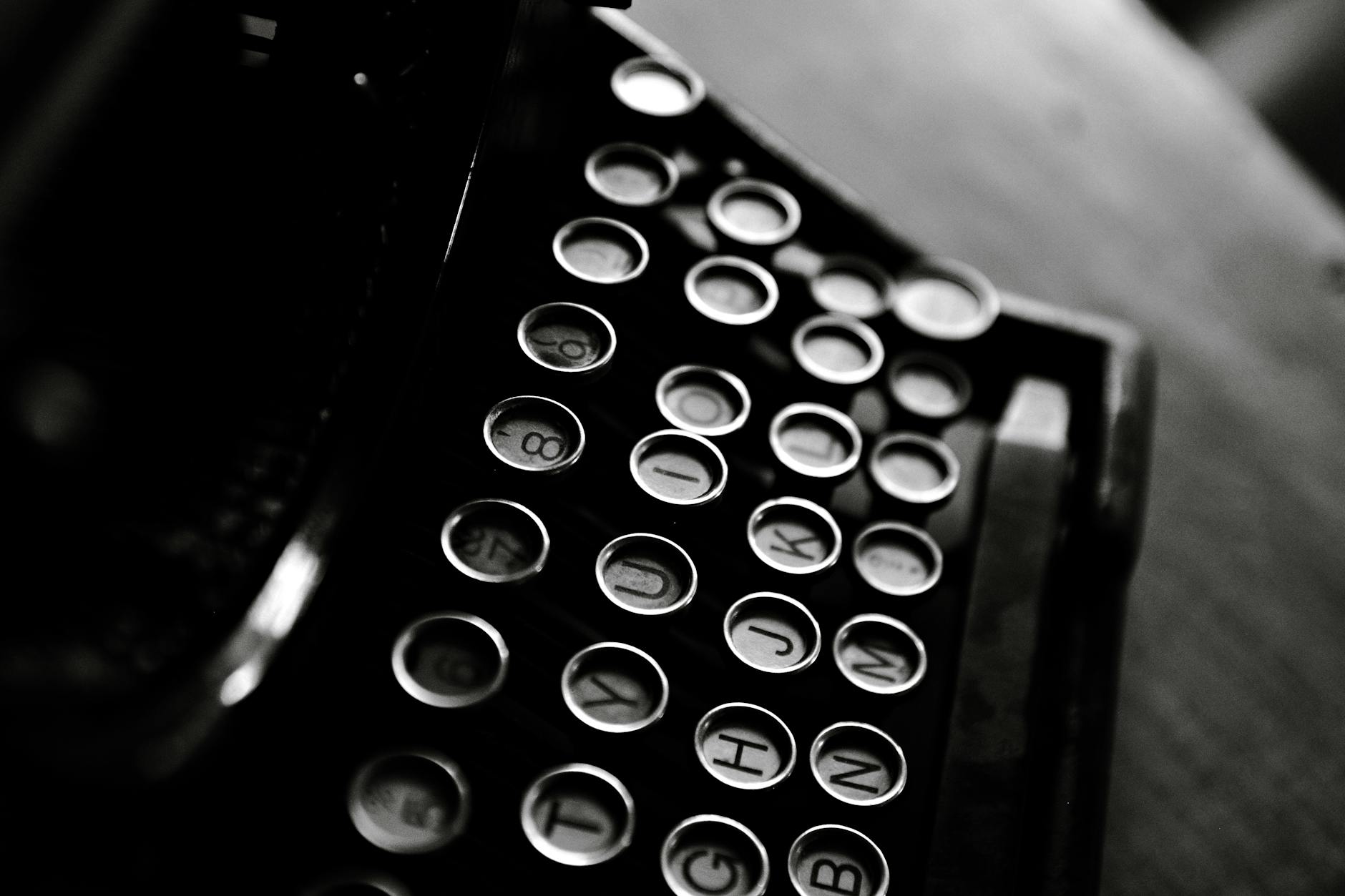 Classic black and white photo of a vintage typewriter showcasing its keys in detail.