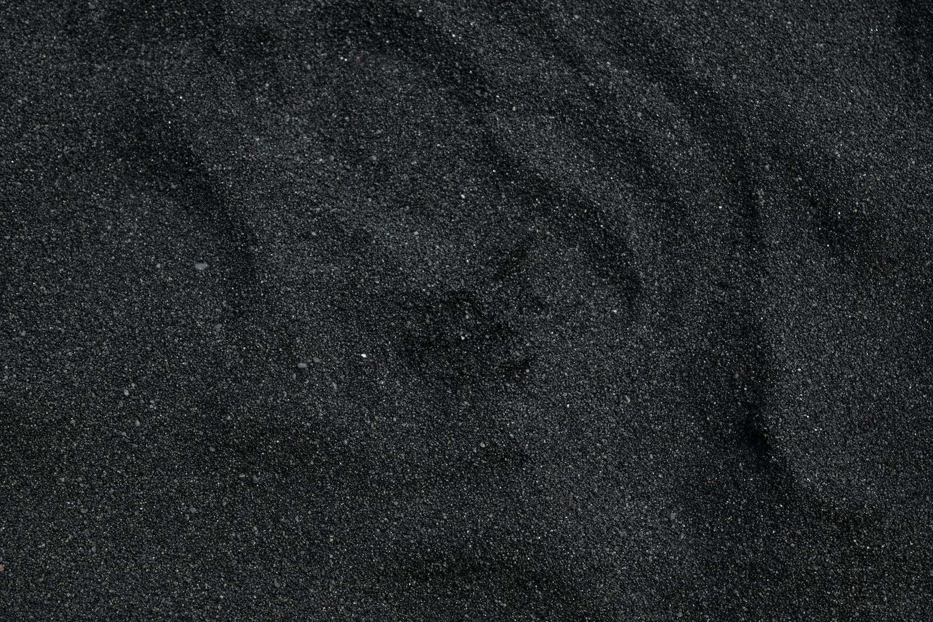 Close-up of black sand texture from Waimea Beach in Hawaii. Ideal for backgrounds.