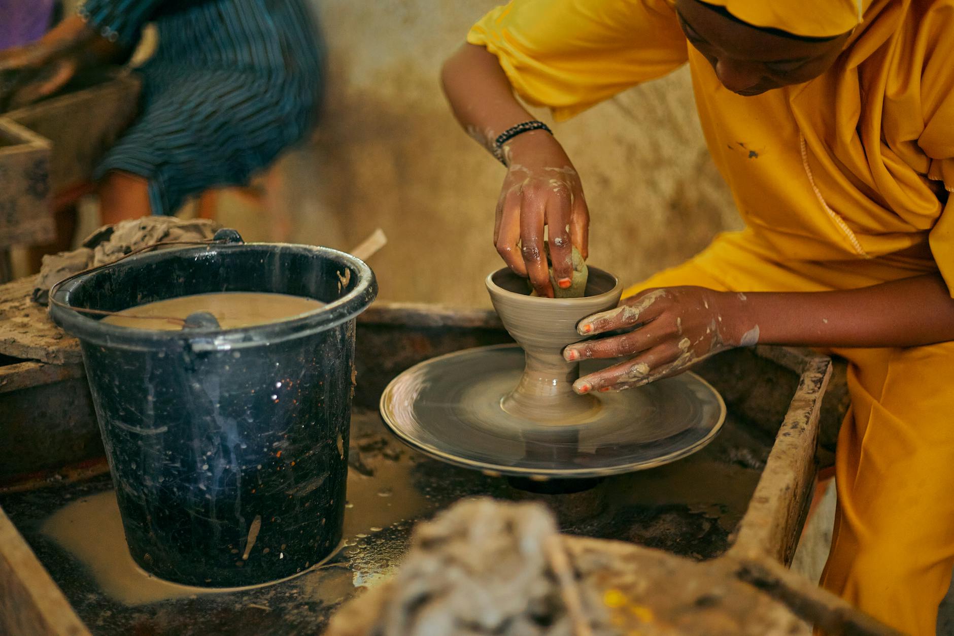 An artisan expertly molds clay on a pottery wheel, showcasing traditional craftsmanship.