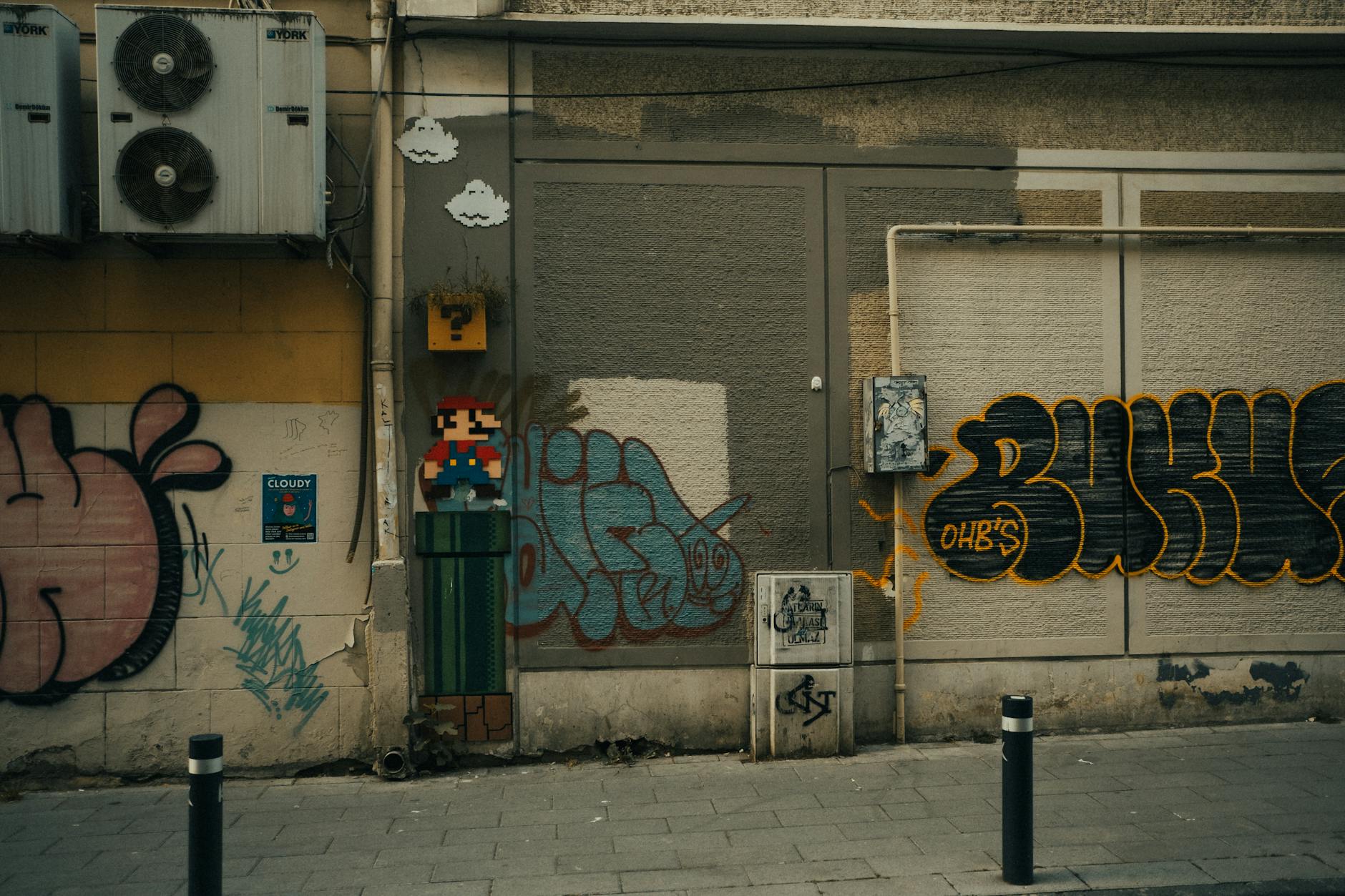 Vivid graffiti and street art featuring Mario on a city wall with visible air conditioning units.