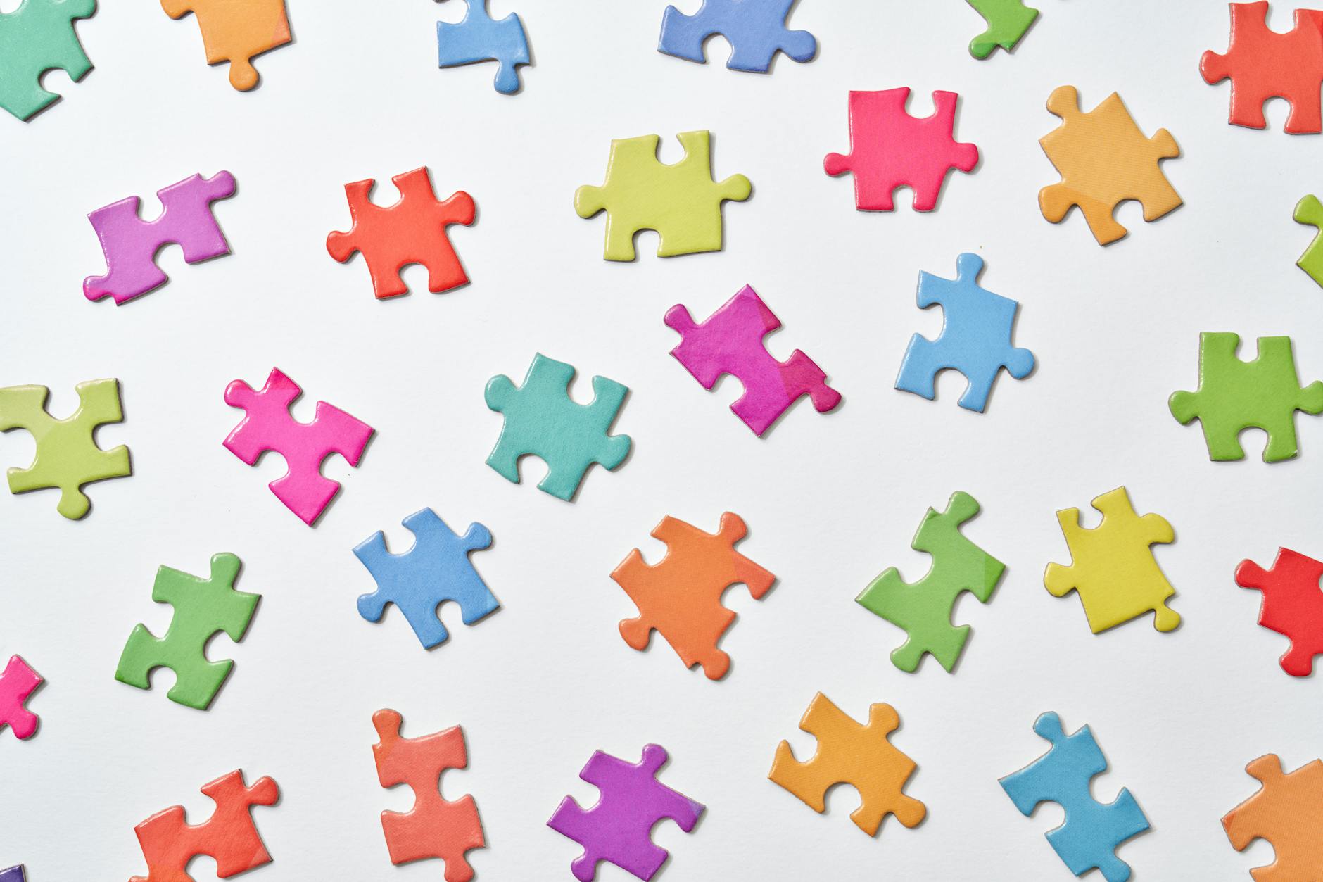 Abstract layout of colorful puzzle pieces on a white surface.