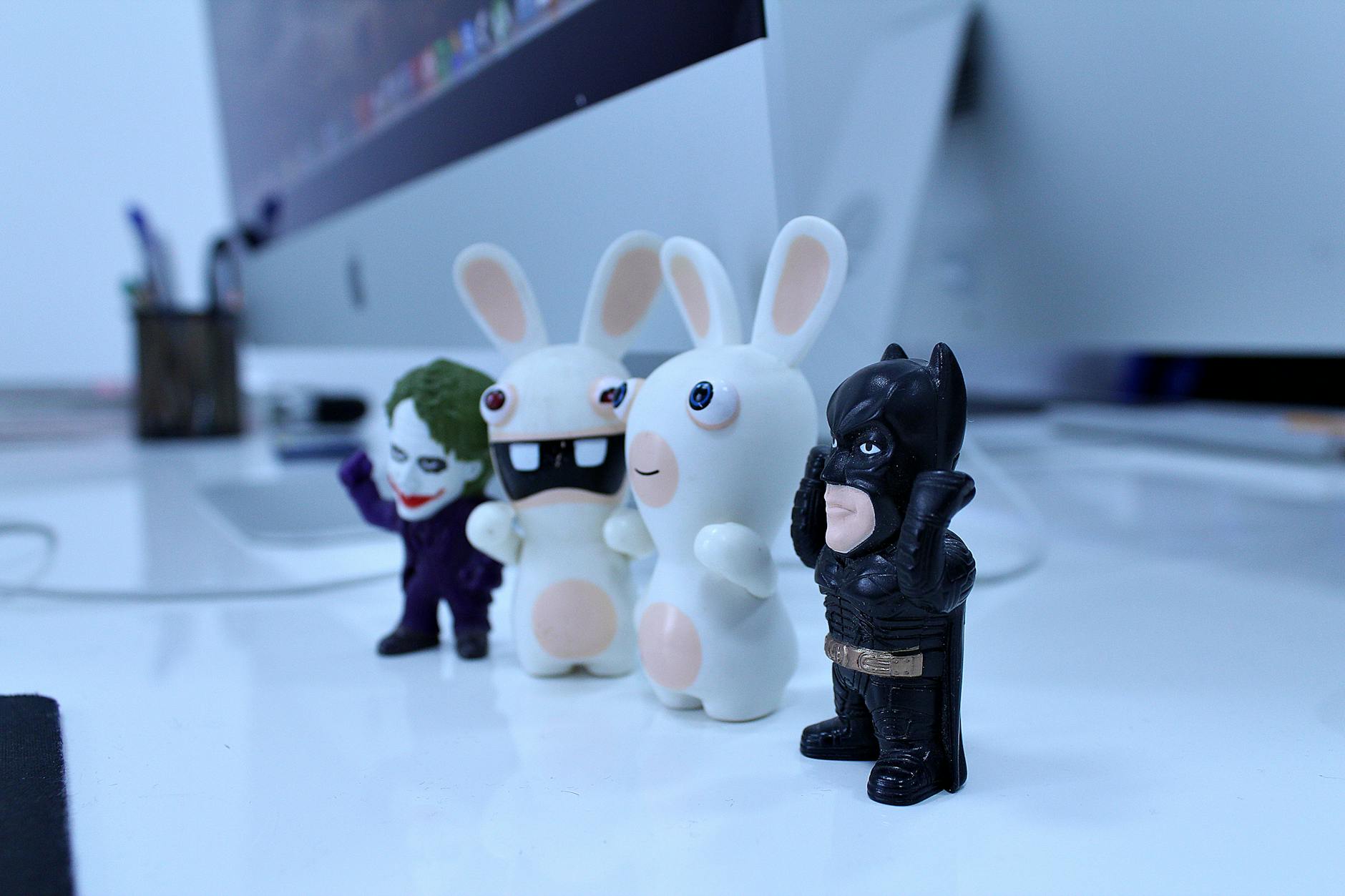 Close-up of various cartoon figurines on a modern desk setting, perfect for creativity-themed projects.