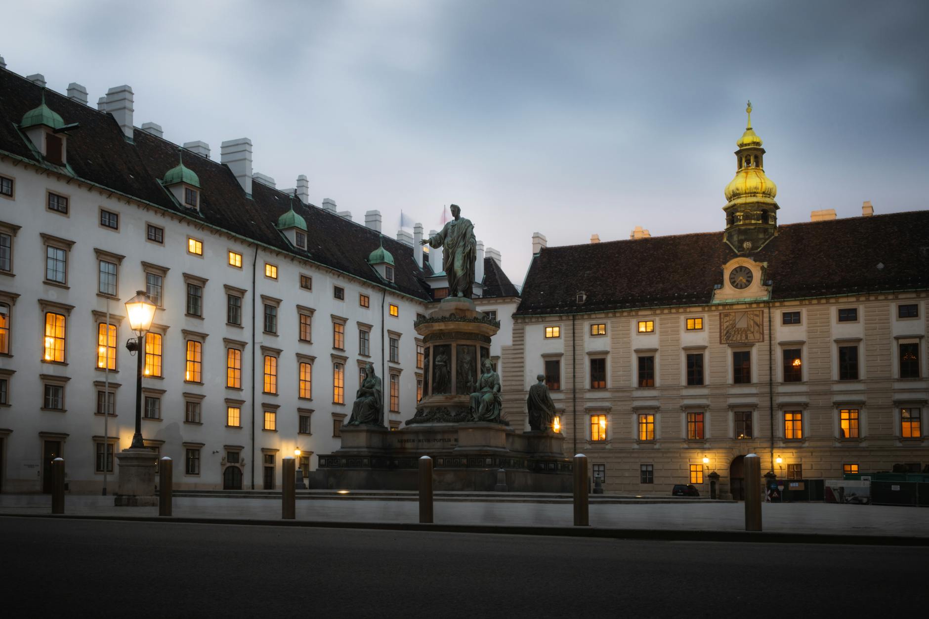 Twilight view of the Hofburg Palace in Vienna, Austria with glowing windows and elegant architecture.