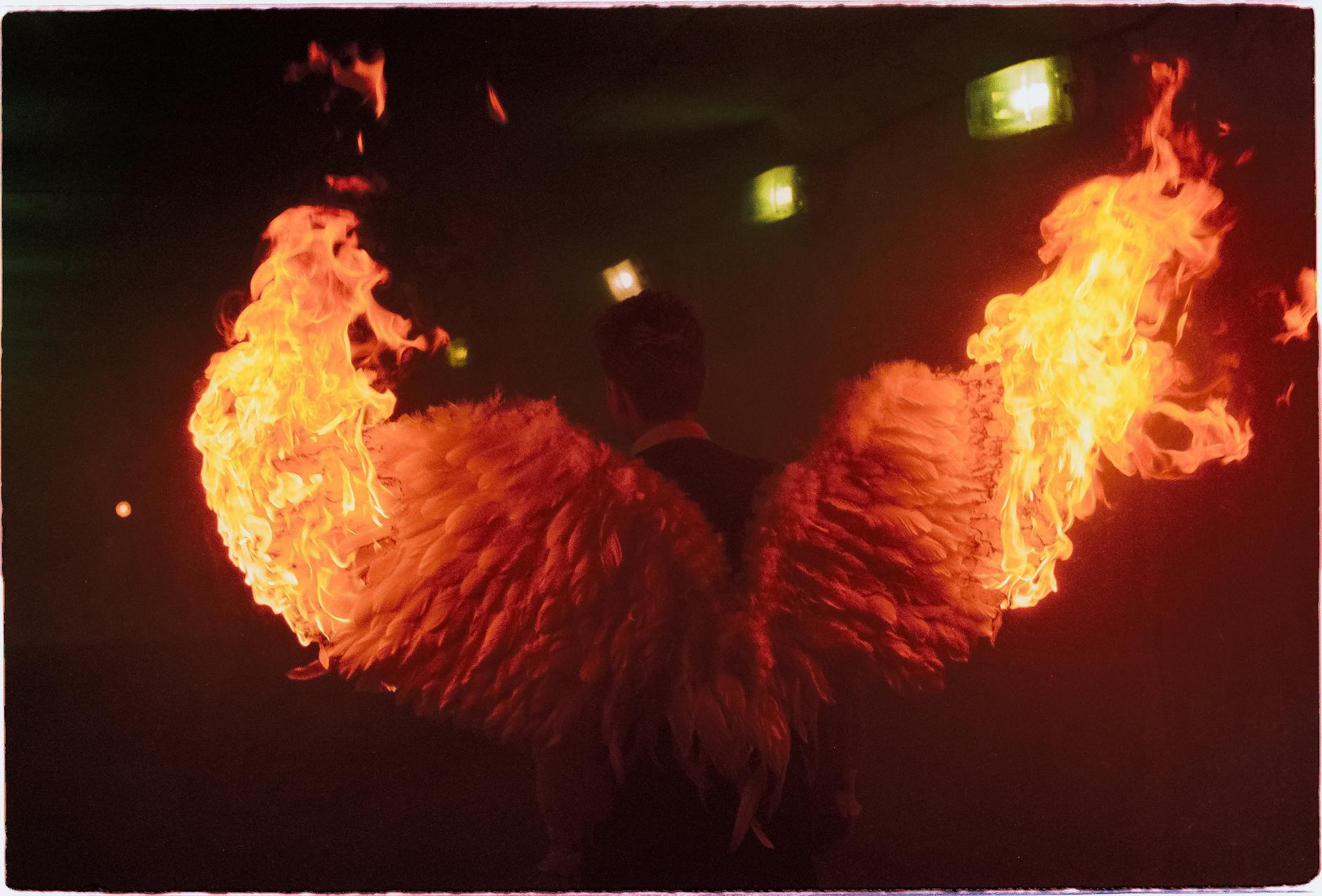 A dramatic image of angelic wings on fire, creating a striking visual in a dark setting.