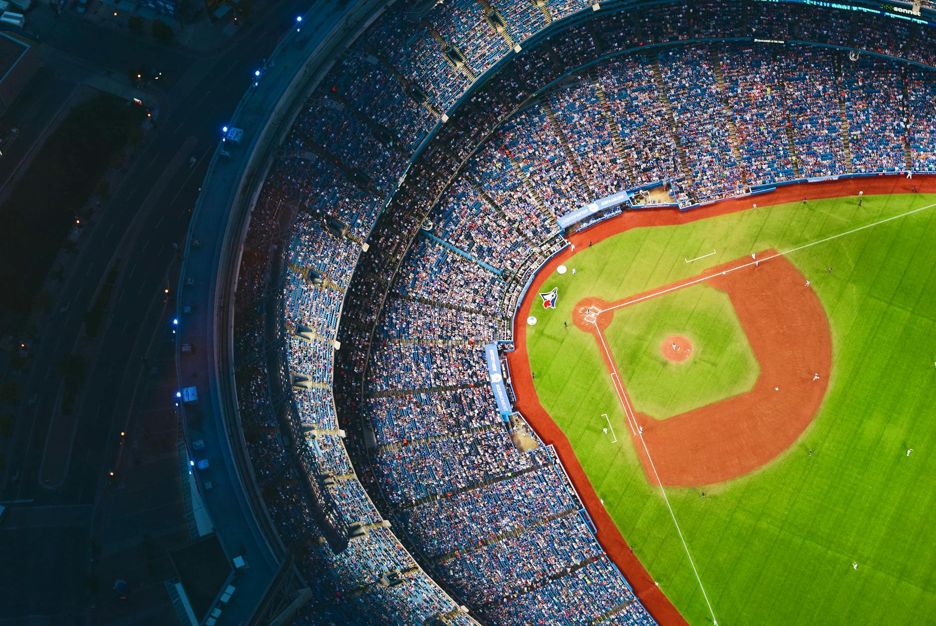 High-angle view of a crowded baseball stadium with green field in Toronto during a game.
