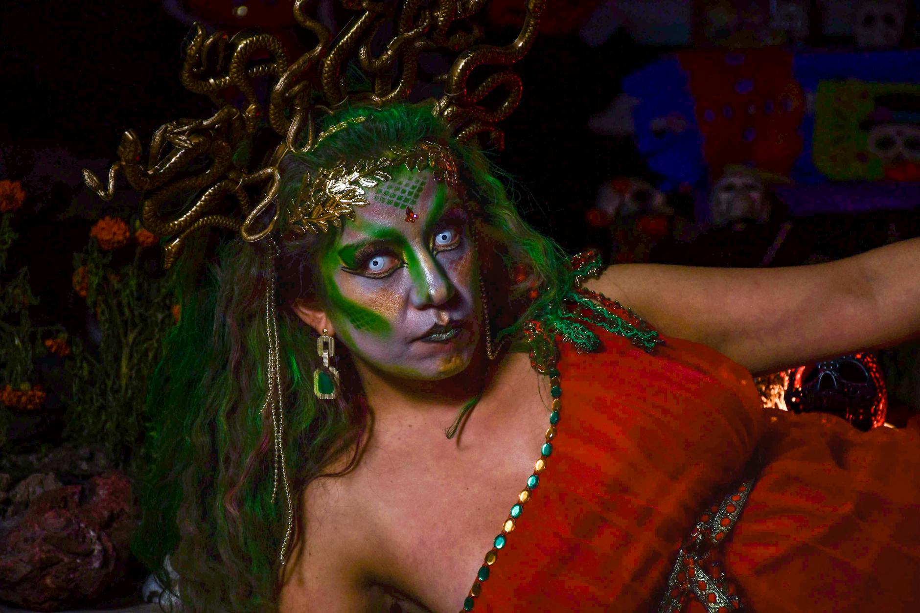 A woman in a detailed Medusa costume with vivid makeup and ornate headdress.