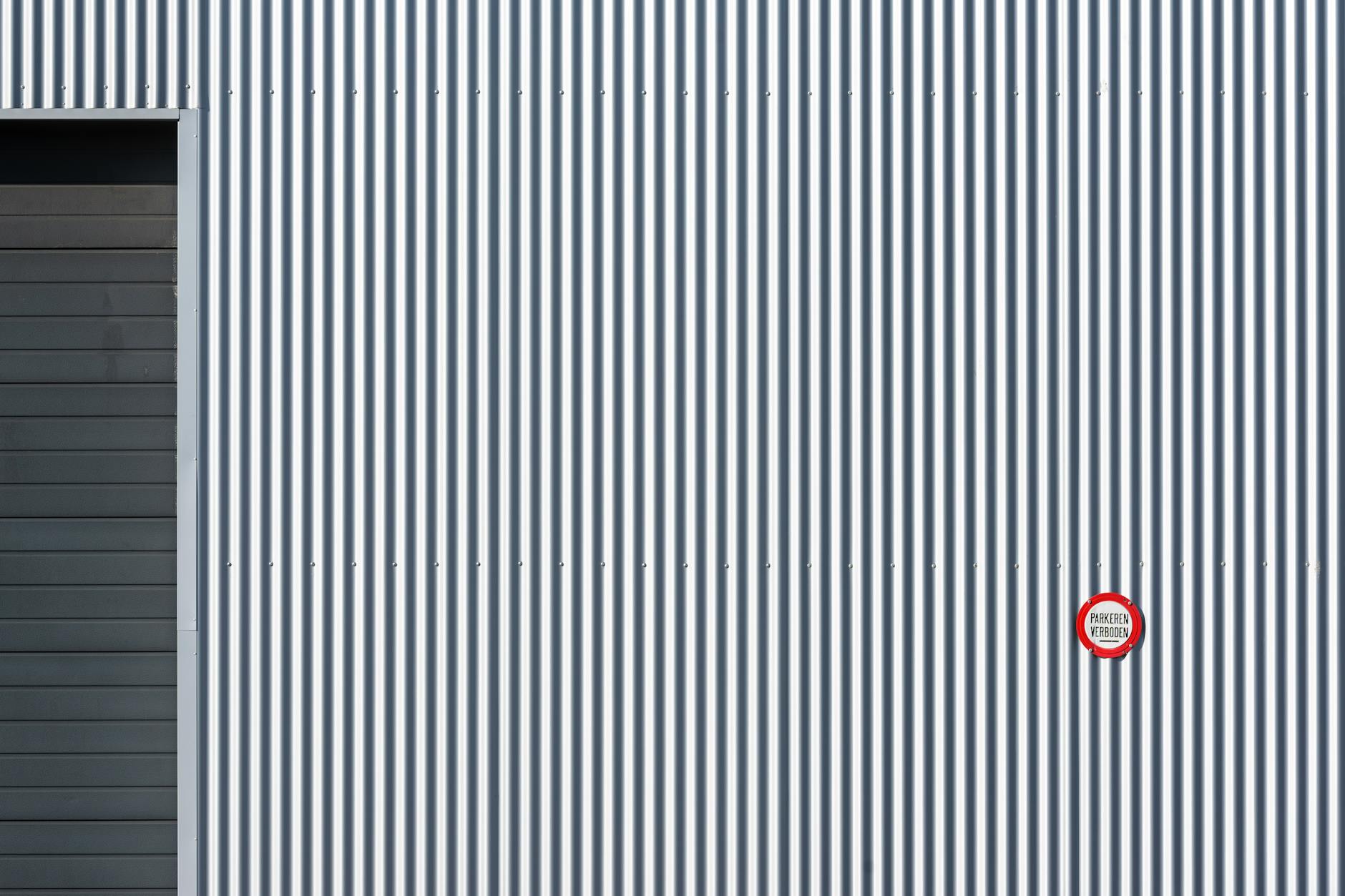 A striped industrial wall with a prohibition sign, offering strong graphic lines.