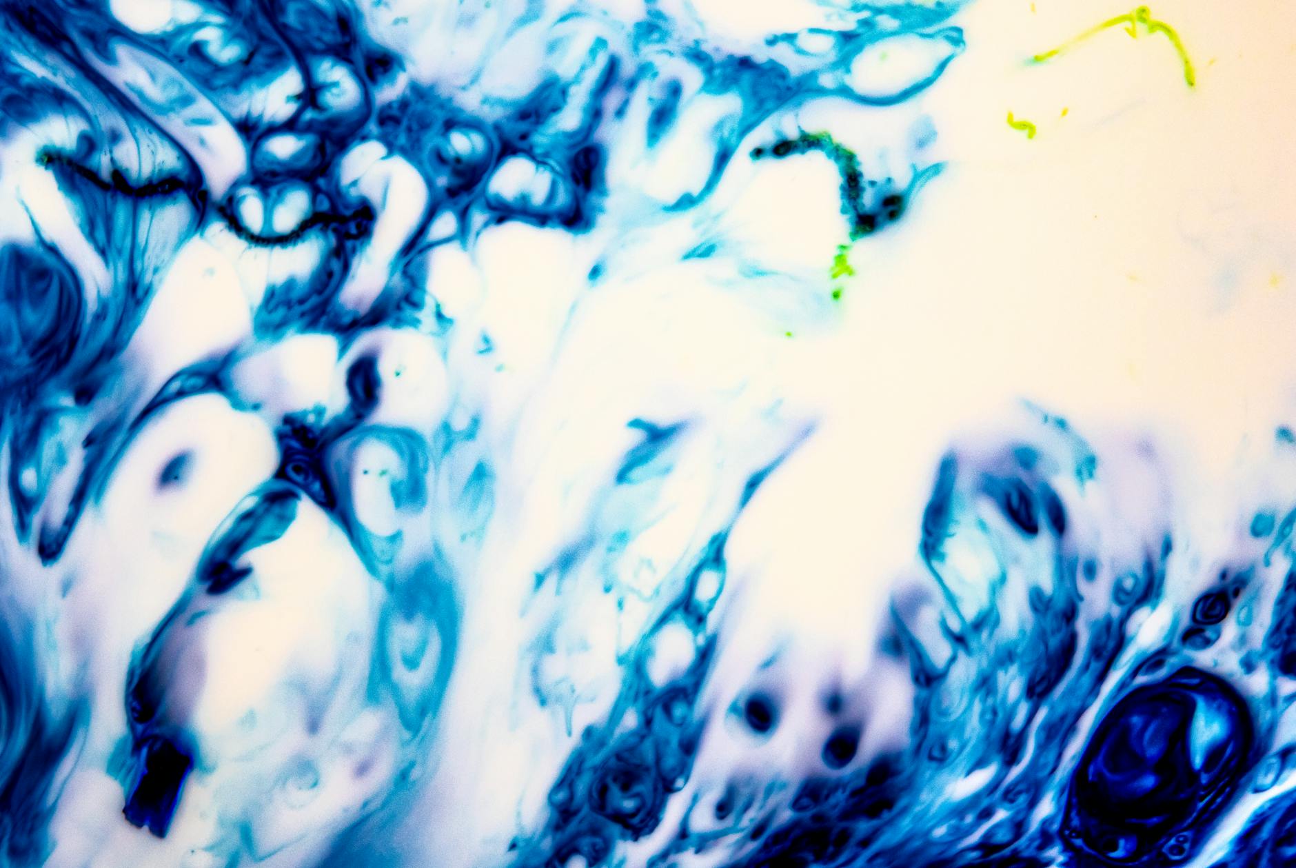 Dynamic abstract artwork featuring swirling blue and white textures with hints of green.