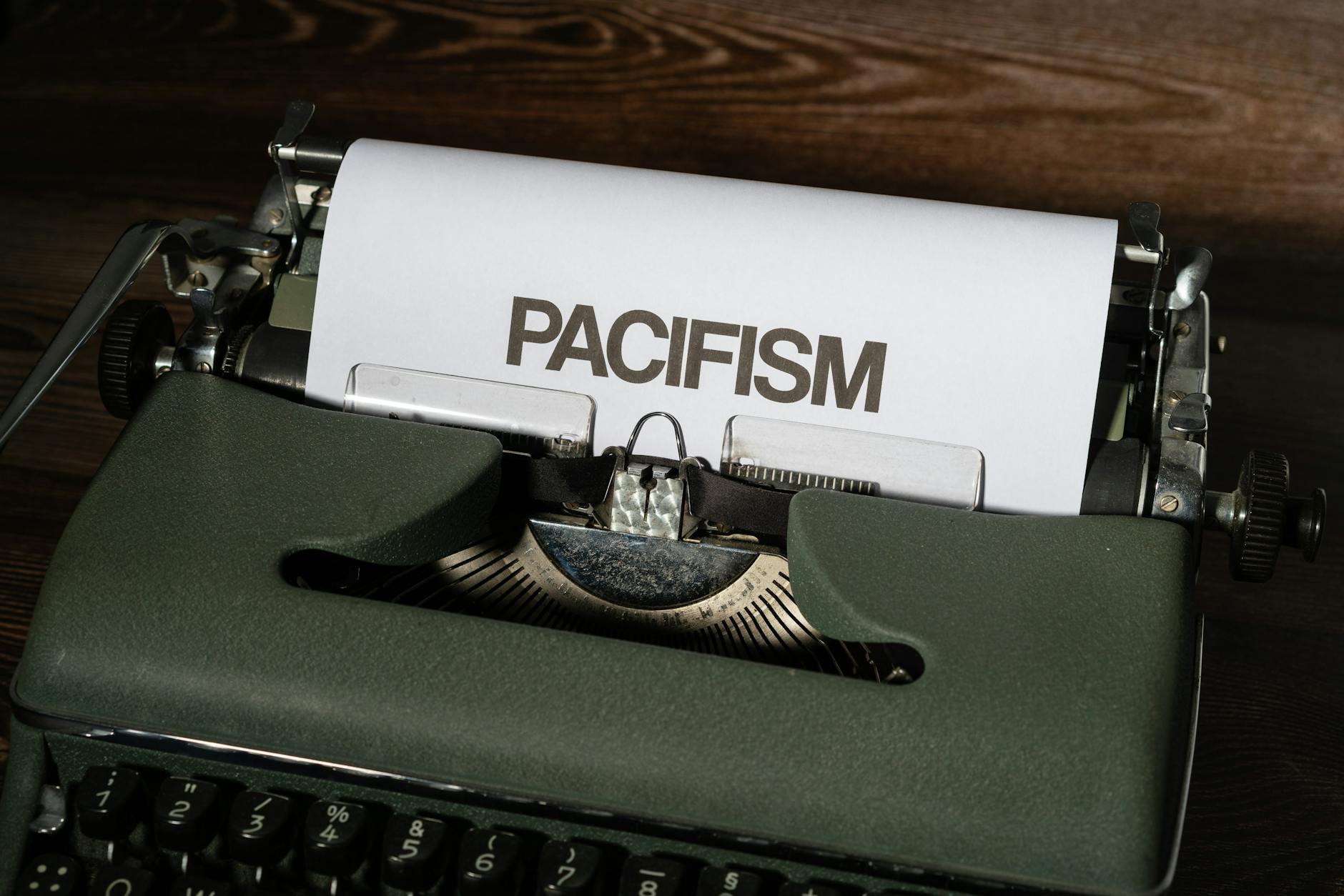 A vintage typewriter displaying the word 'pacifism' on a sheet of paper.