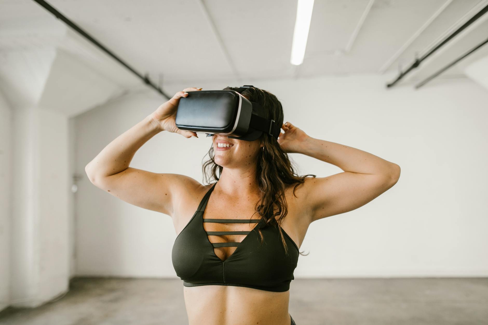 Adult woman in workout attire exploring virtual reality indoors.