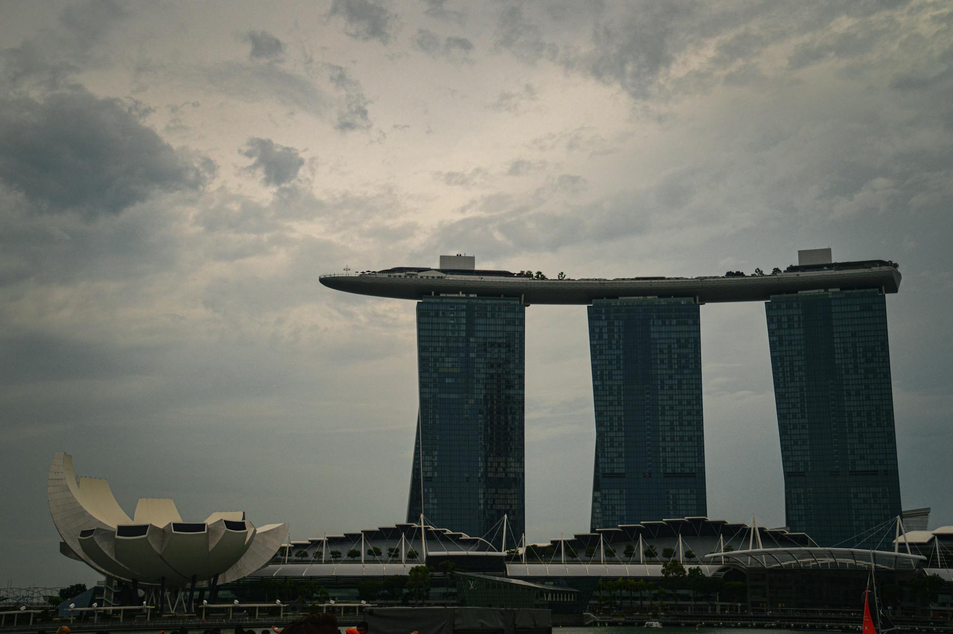 Dramatic view of Marina Bay Sands and ArtScience Museum under cloudy skies in Singapore.