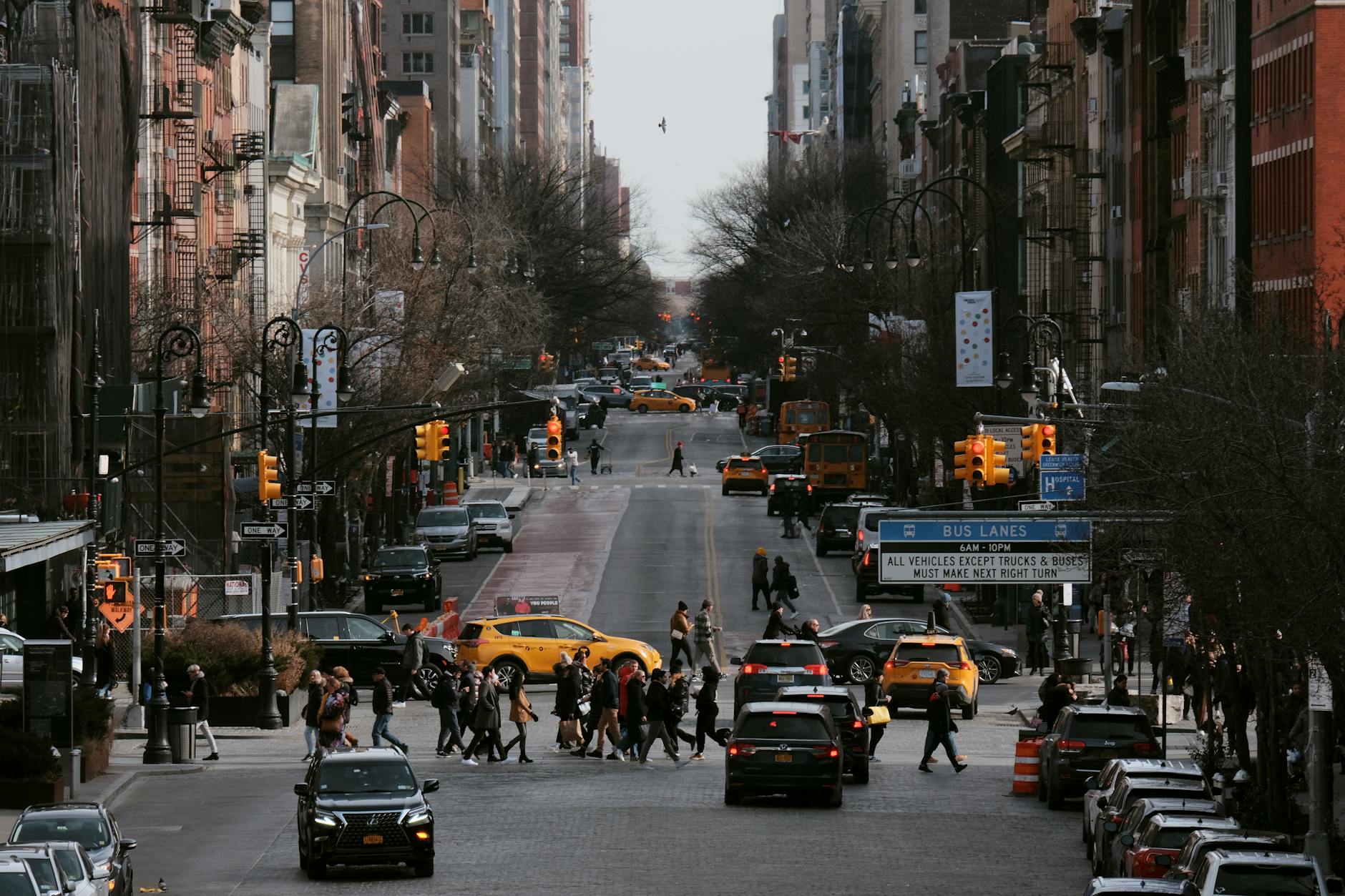 Vibrant New York City street bustling with people, taxis, and skyscrapers in urban daylight.