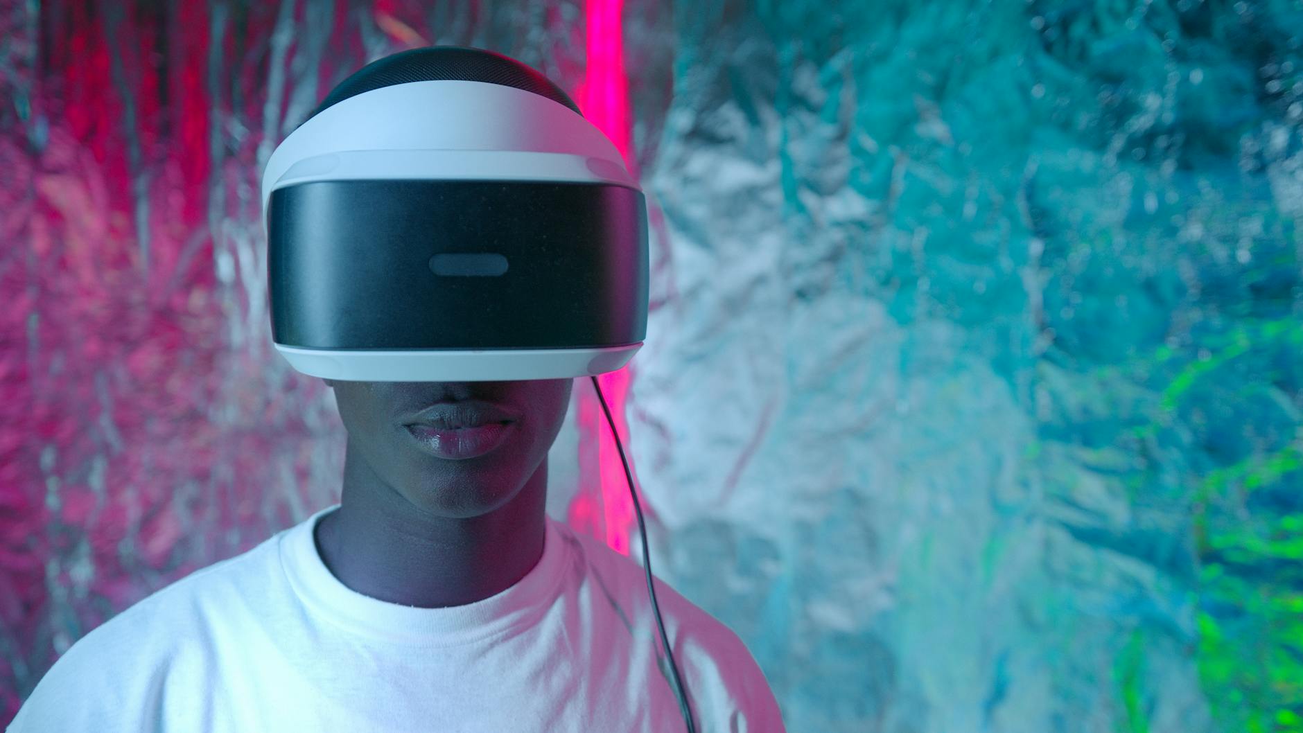 Teen enjoying virtual reality experience with vibrant neon lights.