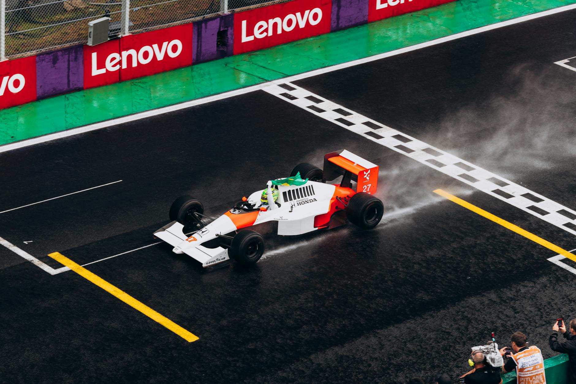 A classic Formula One car races on a wet track, capturing the thrill of motorsport.