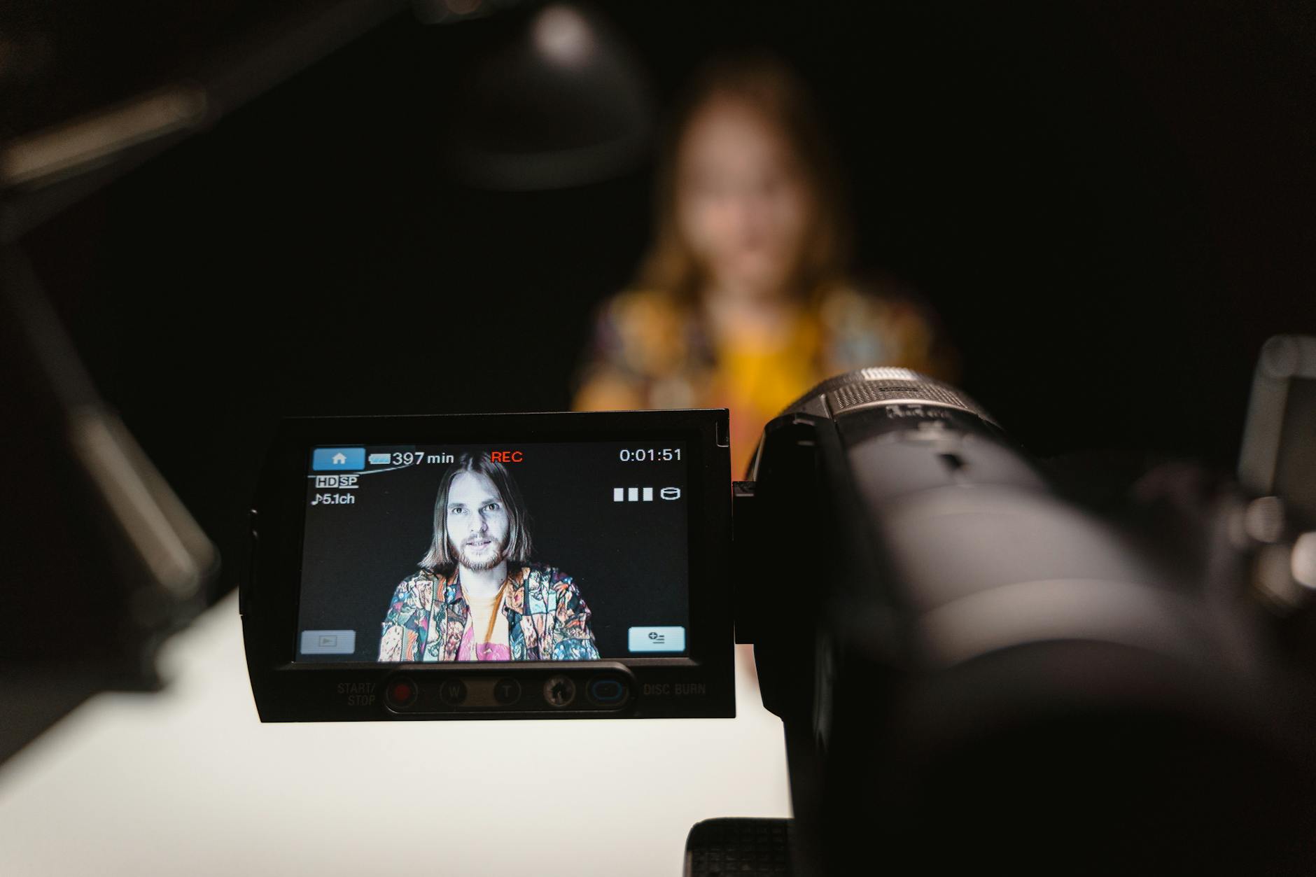 Close-up view of camera capturing a person's portrait in a recording studio.