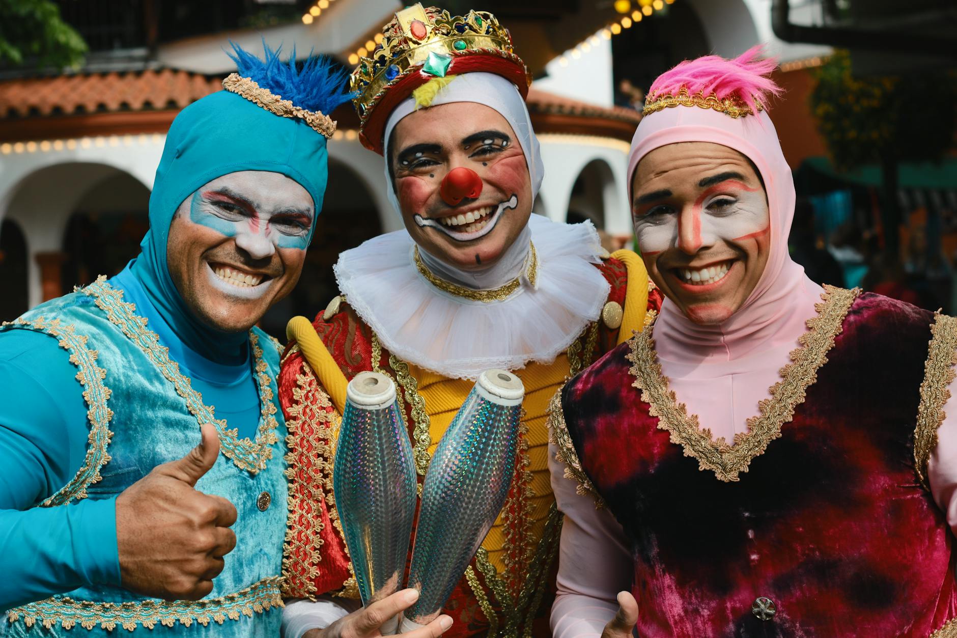 A group of colorful clowns in costume performing at an outdoor festival, showcasing joy and entertainment.