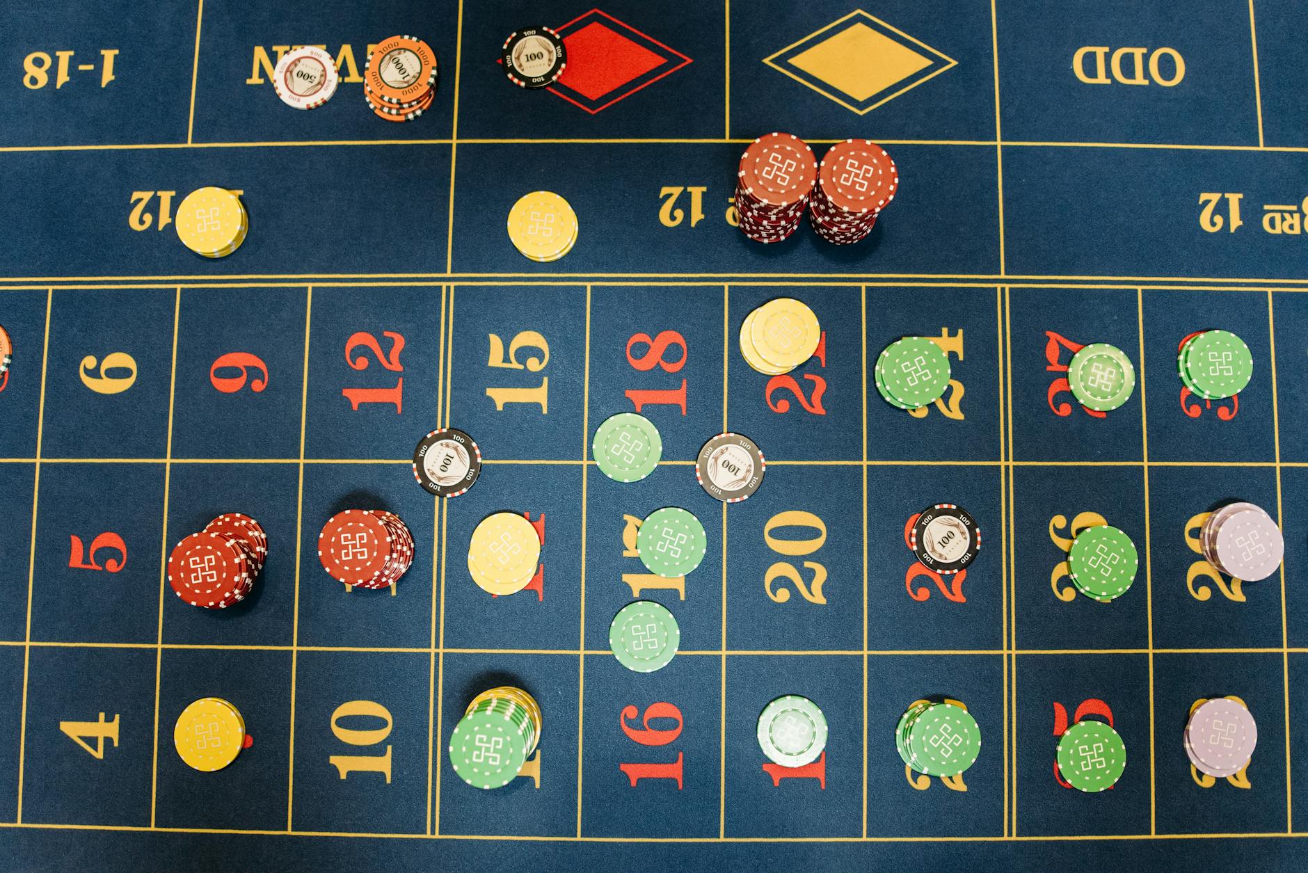 Aerial view of a roulette table with colorful poker chips showing a vibrant gambling scene.