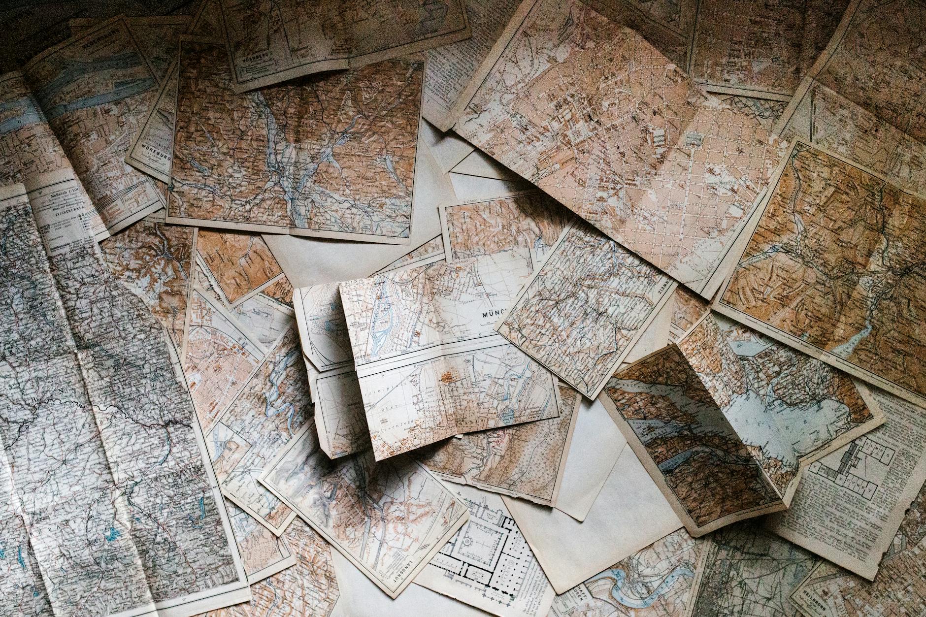 A collection of vintage maps scattered for exploring world journeys and discoveries.