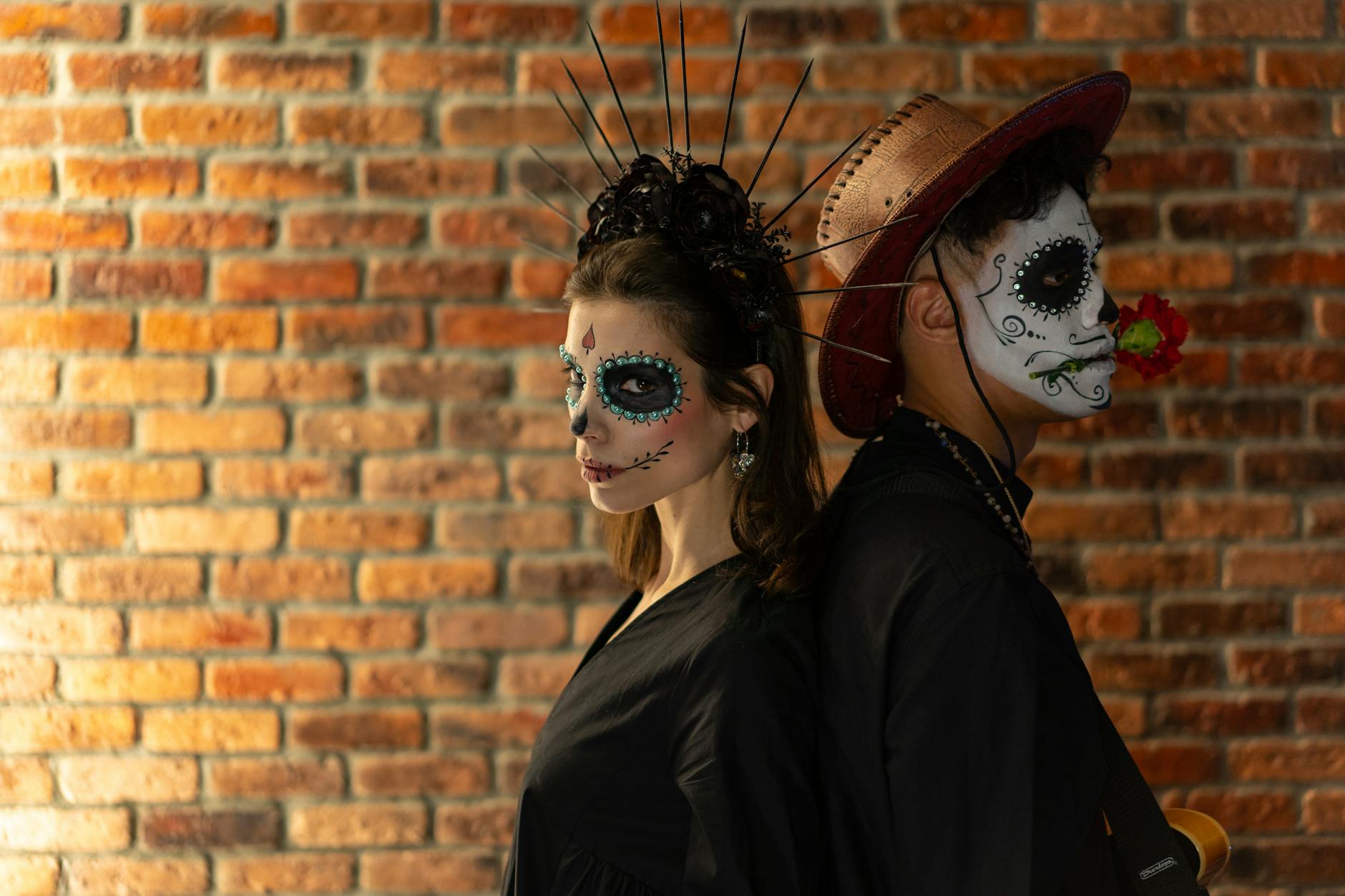 Elegant Dia de los Muertos themed portrait with intricate face paint and traditional outfits.