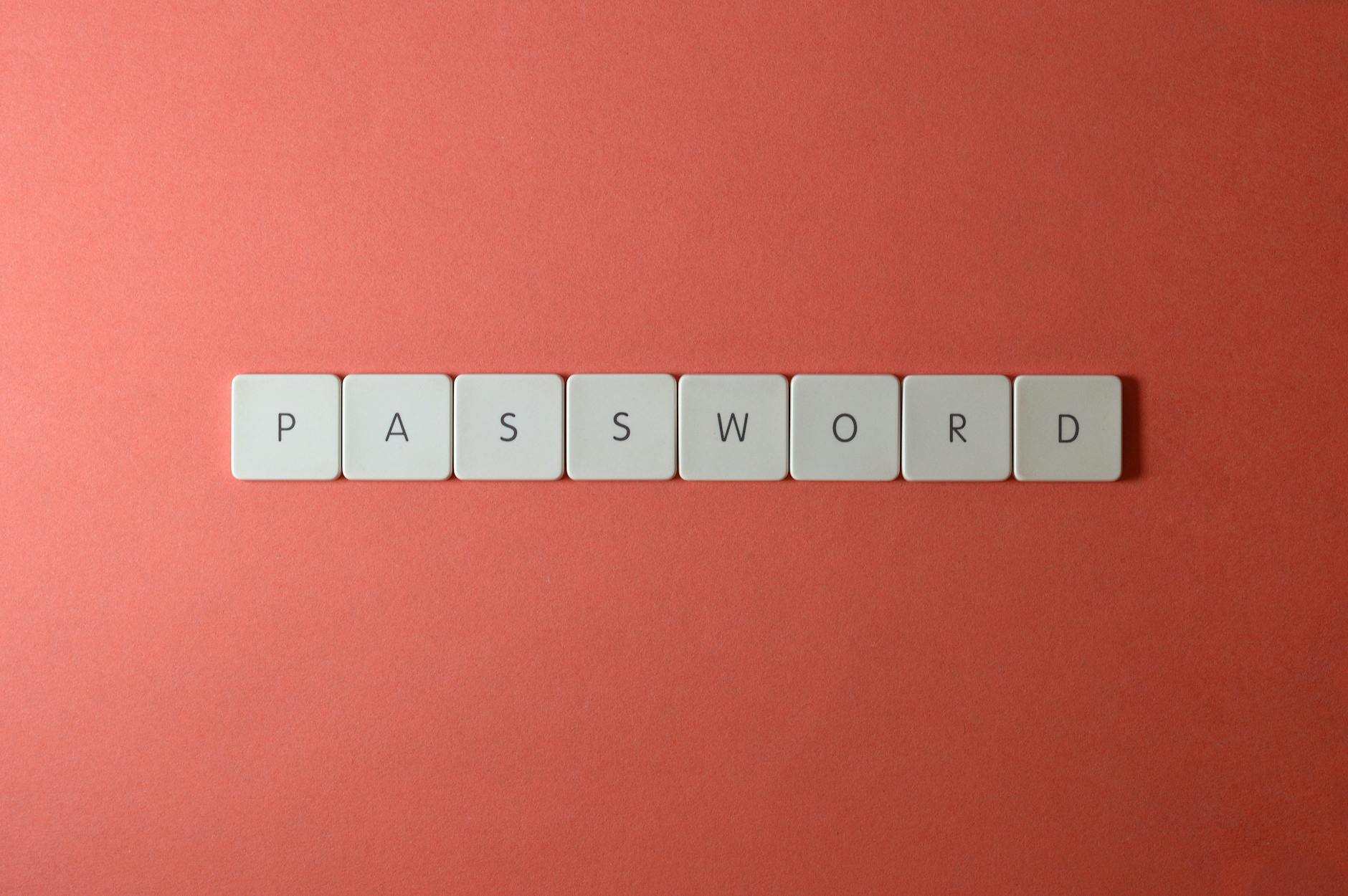 Focus on password security with white keyboard tiles spelling 'PASSWORD' on a coral background.