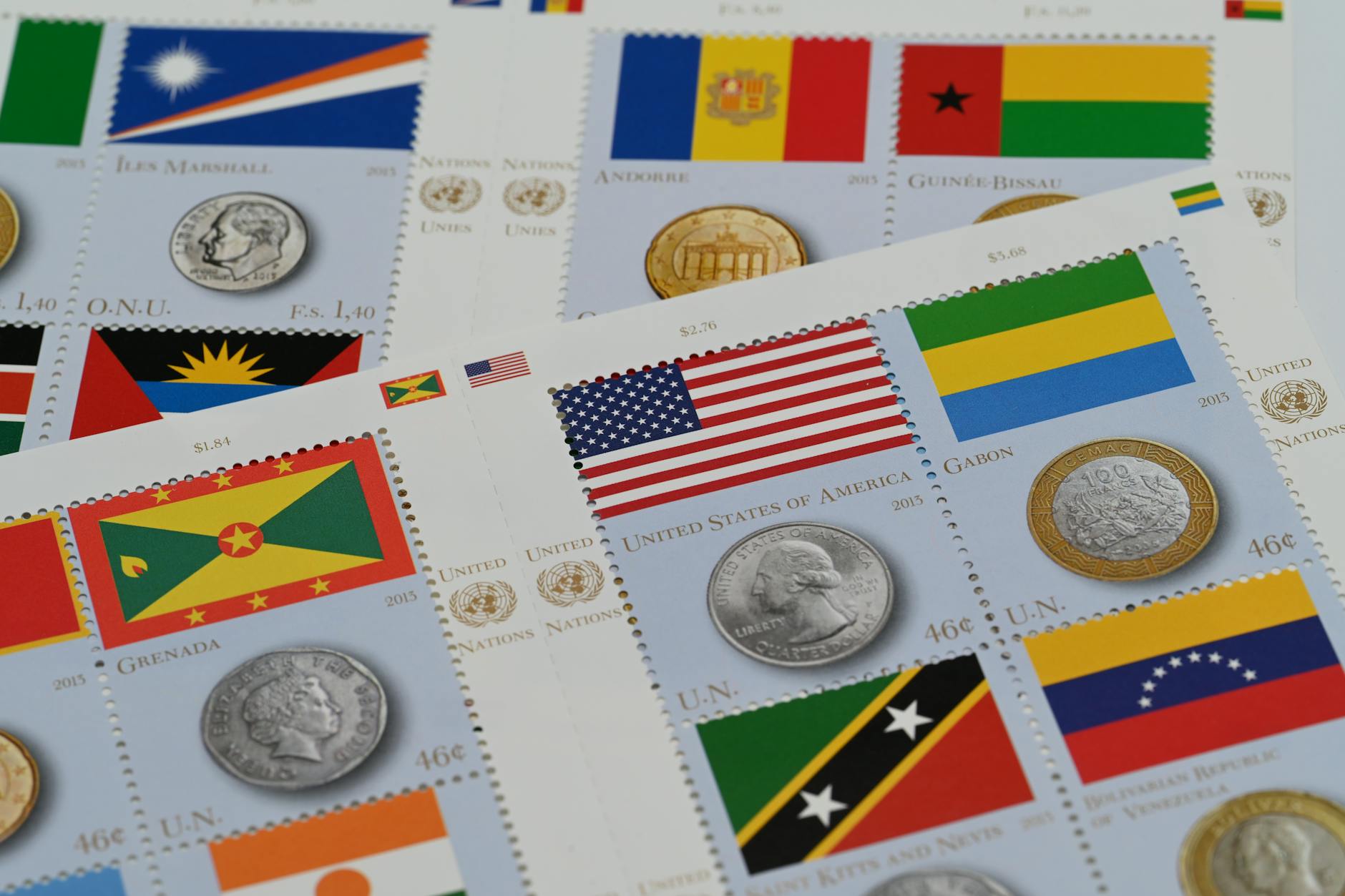 A close-up of international stamps and coins featuring country flags, promoting global culture.