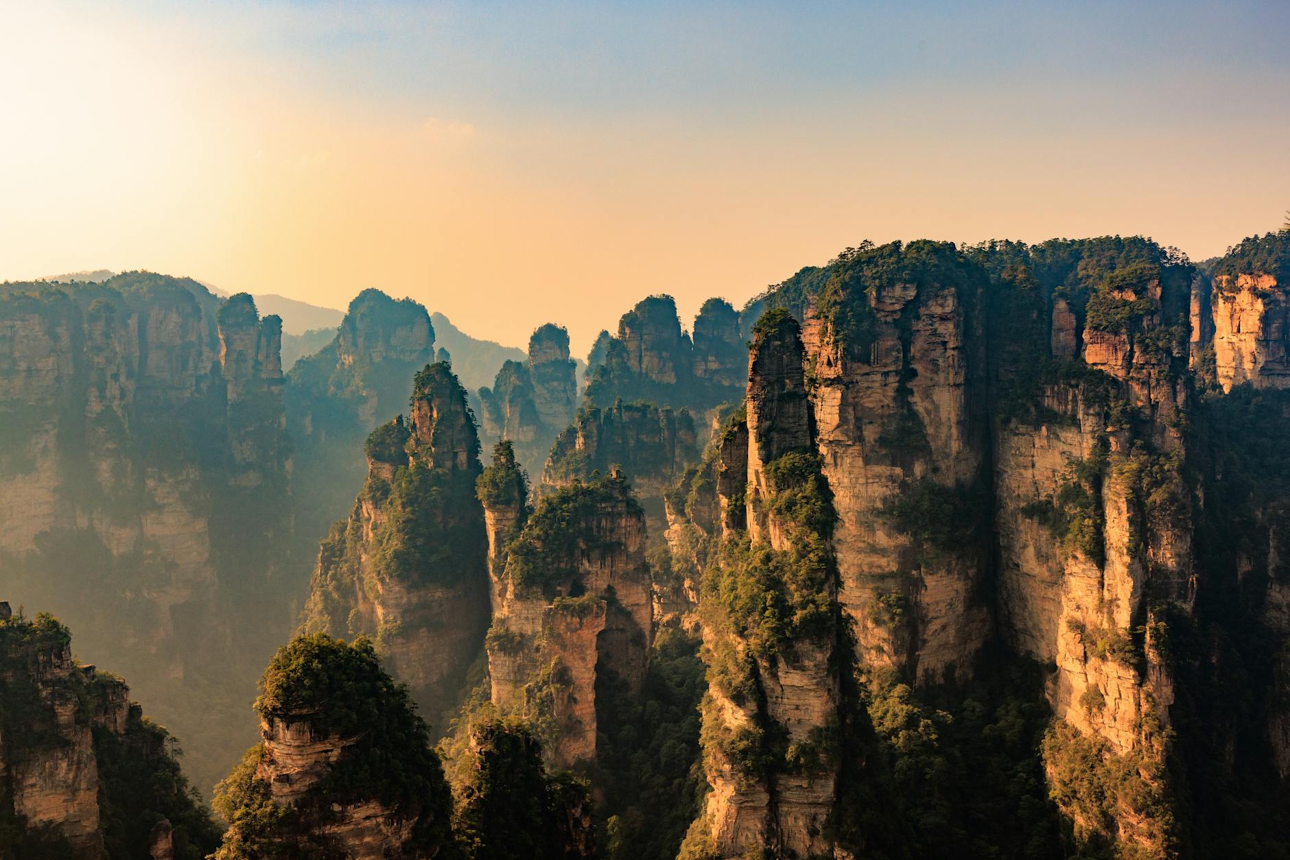 Stunning view of the towering sandstone pillars in Zhangjiajie National Forest Park at sunrise.