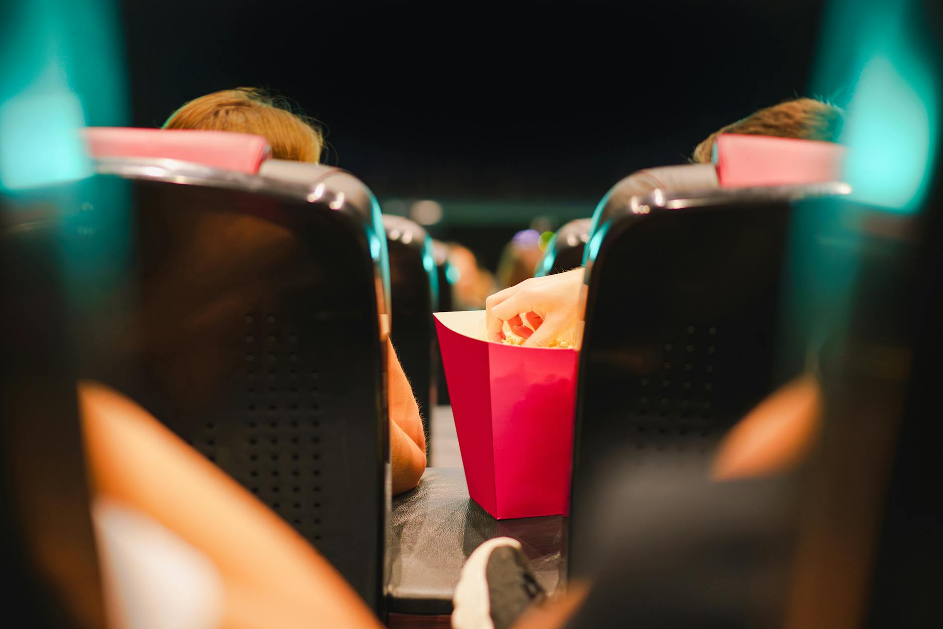 Group enjoying popcorn in a contemporary cinema setting, enhancing the movie experience.